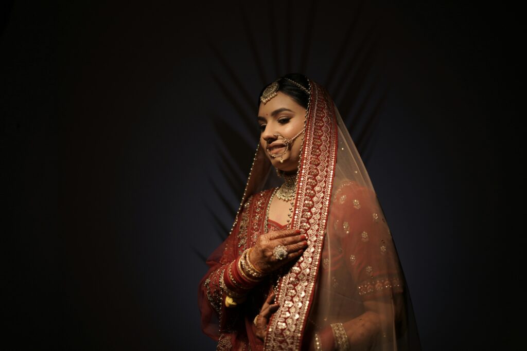 A stunning bride in traditional Indian attire with intricate jewelry and henna designs.